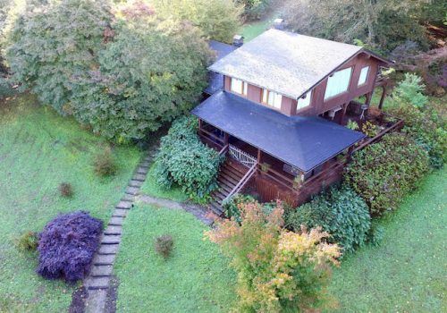 Casa oasis estilo americano de madera entre frondoso bosque