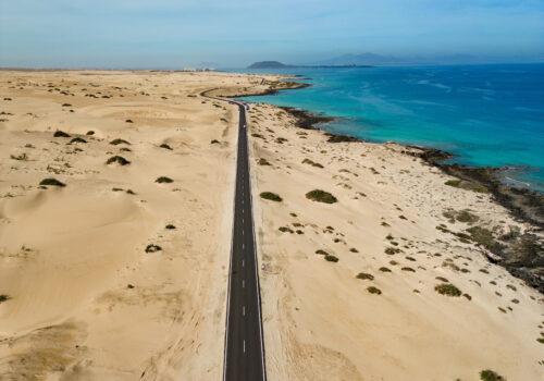 Carreteras entre paisaje desértico frente a mar