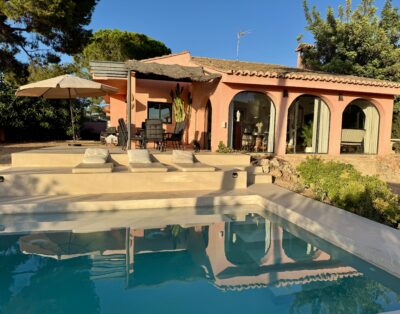 Casa rosa mediterránea con interiores artísticos y piscina