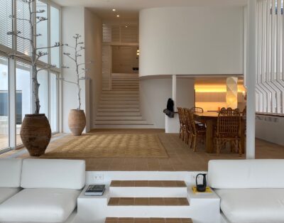Villa blanca mediterránea con piscina entre acantilados